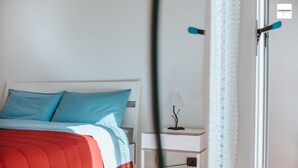 Ein Schlafzimmer mit einem Bett, einem Nachttisch und einer Lampe.
