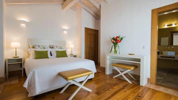 Un dormitorio con cama, mesitas de noche, un escritorio y un banco.