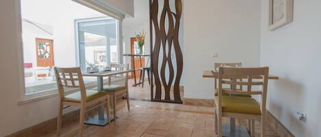 A dining area with two wooden chairs, a table, and a decorative partition.