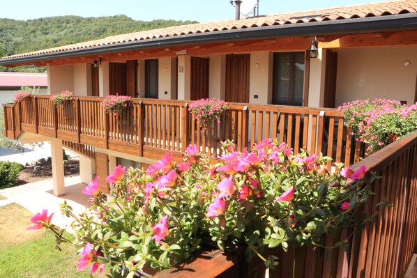 A hotel with a wooden balcony, flower boxes, and a view of a lake.
