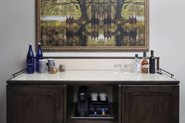 A bar area with bottles, glasses, and a coffee machine. - The Ben, Autograph Collection (West Palm Beach)
