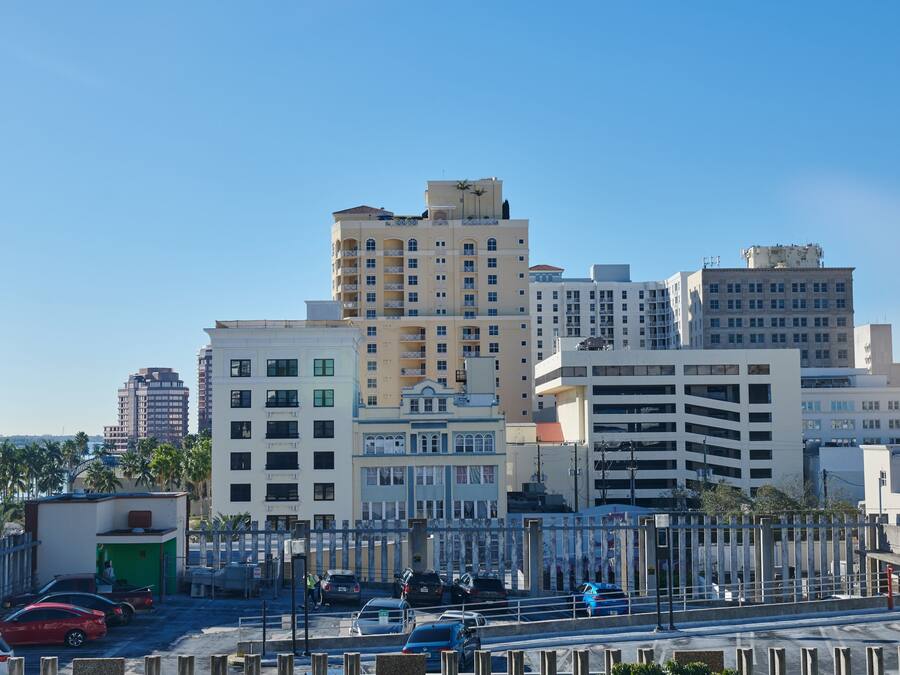 A multi-story hotel with a central courtyard, surrounded by other buildings.