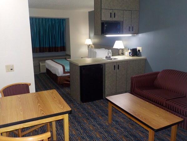 Cozy retreat with a single bed, kitchenette, and sofa, perfect for a compact stay.
