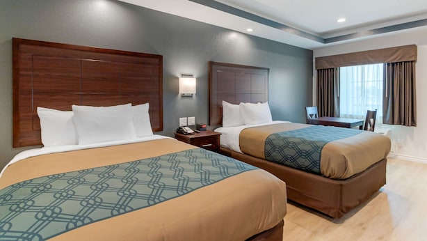 A hotel room with two beds, a desk, and a chair. - Econo Lodge Houston Northwest - Cypress (Houston)