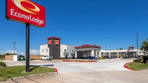 A commercial building with a prominent EconoLodge sign, a gas station, and a parking lot. - Econo Lodge Houston Northwest - Cypress (Houston)