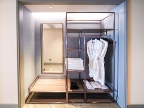 A walk-in closet with a mirrored wardrobe, shelves, and a hanging robe rack. - Mercure Xian Qujiang (Xi'an)