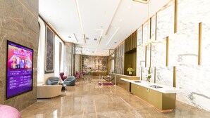 A modern lobby with a reception desk, seating area, and a large digital display. - Mercure Xian Qujiang (Xi'an)