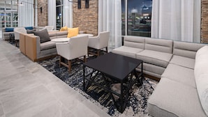 A modern lounge area with sofas, a coffee table, and a stone accent wall. - Hyatt Place Bakersfield (Bakersfield)