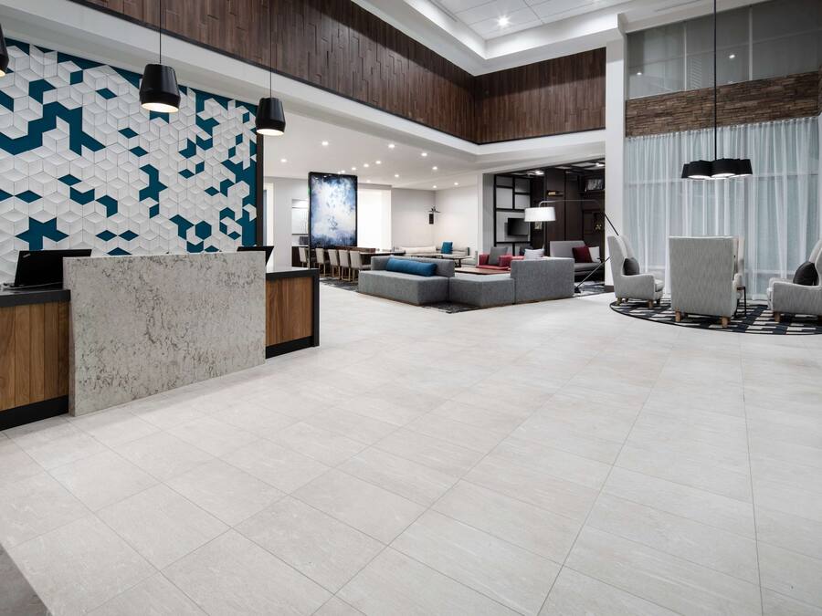 A spacious lobby with a reception desk, seating area, and modern decor.