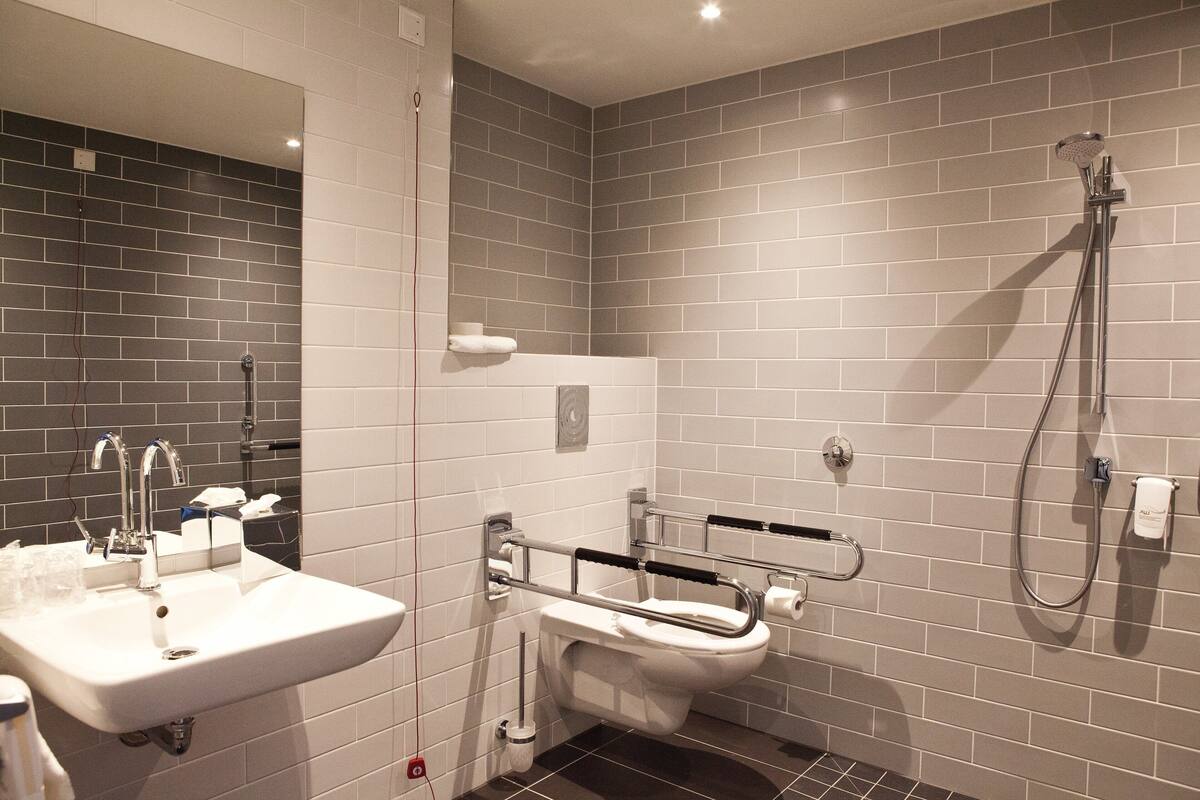 Une salle de bain moderne équipée d’un lavabo, de toilettes et d’une douche.