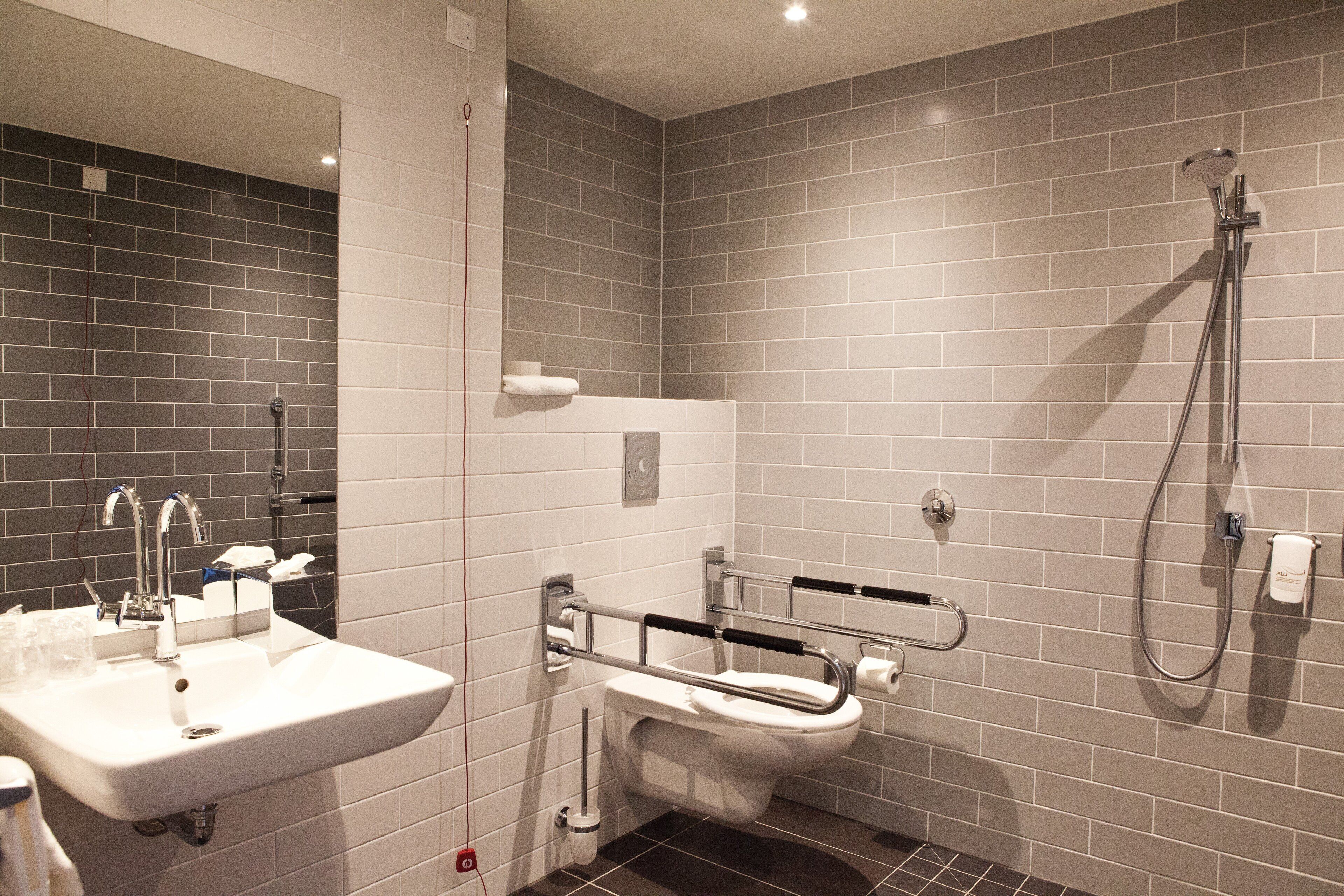 A bathroom with a sink, toilet, and shower.