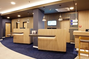 A reception area with a desk, two seating areas, and a sign indicating the Holiday Inn Express.