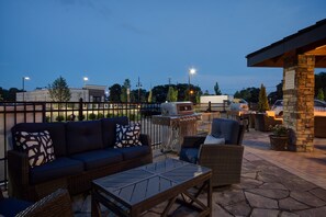 An outdoor patio area with a sofa, chairs, and a grill. - Staybridge Suites Sterling Heights - Detroit by IHG (Sterling Heights)