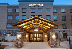 A Staybridge Suites hotel entrance with a stone facade, a covered entrance, and a modern design. - Staybridge Suites Sterling Heights - Detroit by IHG (Sterling Heights)