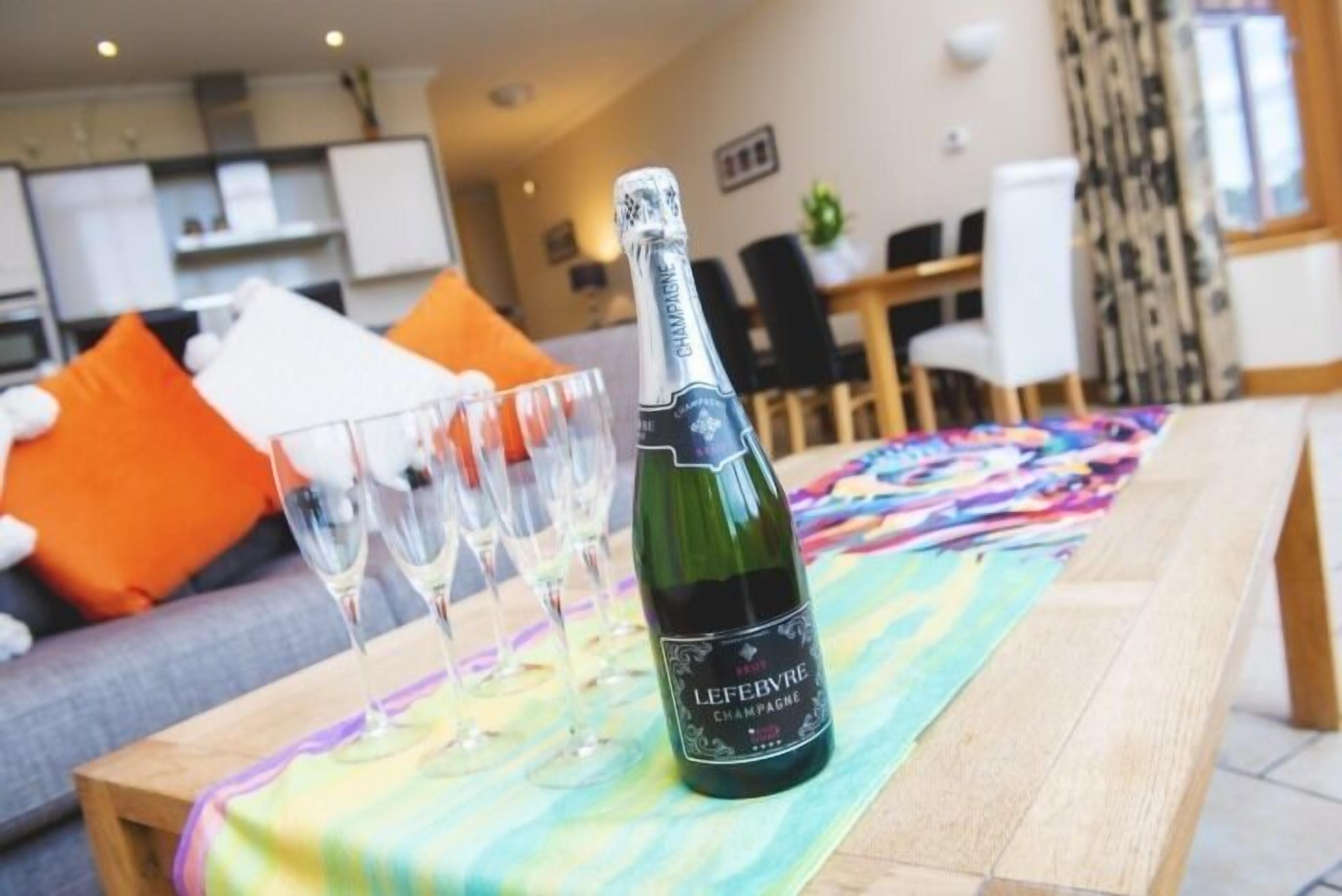 Eine Flasche LeFebvre Champagner auf einem Tisch mit mehreren Gläsern.