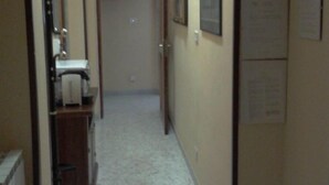 A narrow hallway with a sink and cabinets on the left, a door at the end, and a bulletin board on the right. - Gatto Bianco Picone 19 (Bari)