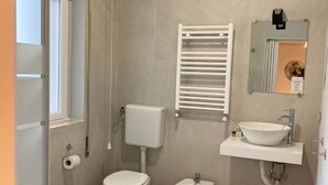 A small, modern bathroom with a toilet, bidet, and sink. - Gatto Bianco Picone 19 (Bari)