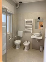 Un bagno moderno e piccolo con water, bidet e lavandino.