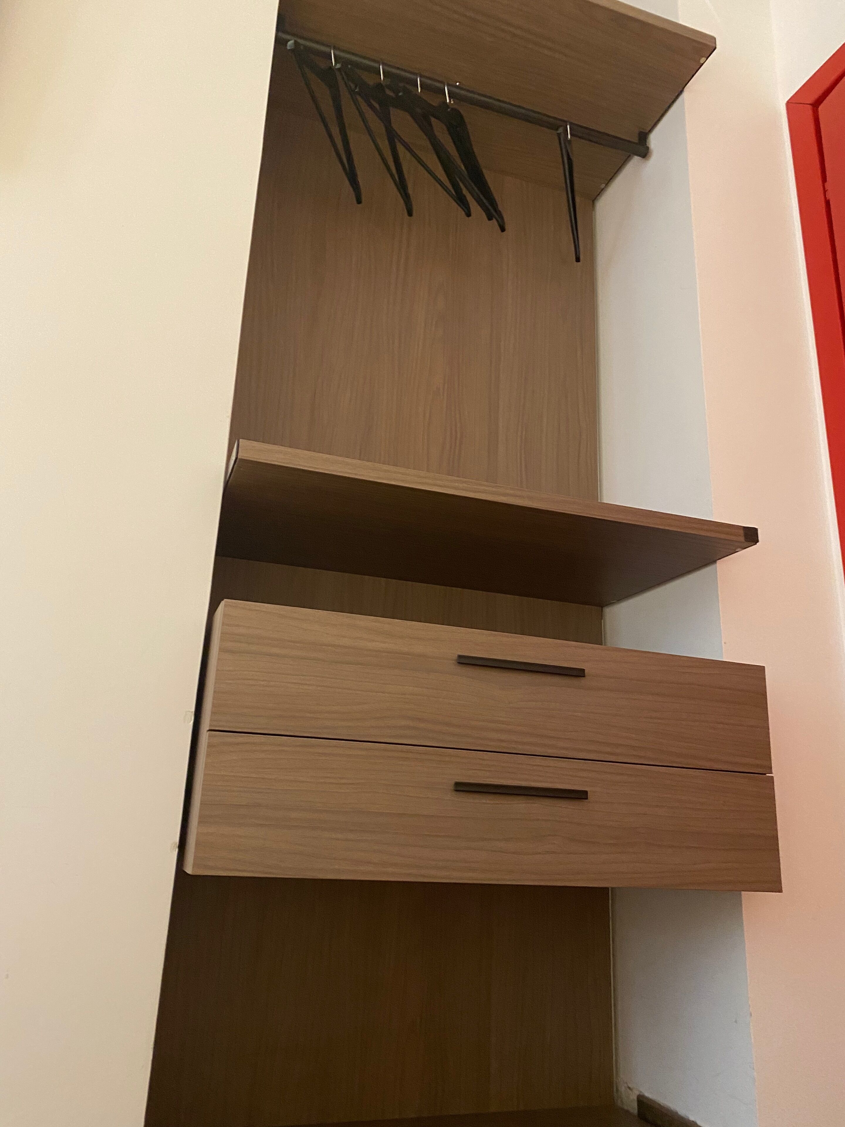 A wooden wardrobe with two drawers and a hanging rod.