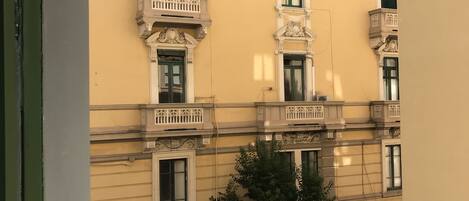 A yellow building with ornate balconies and multiple windows.