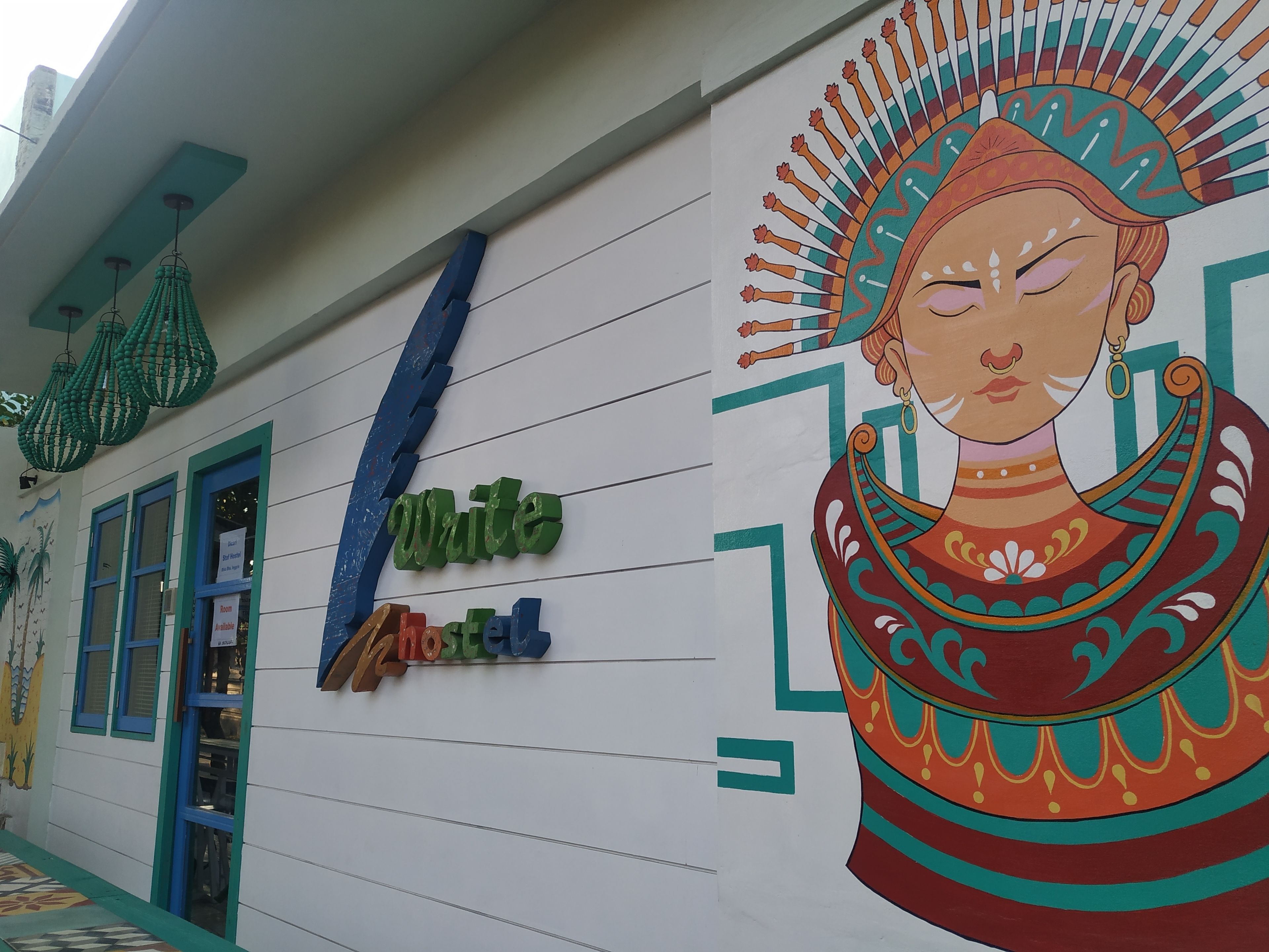 Um mural colorido retrata uma mulher com um headdress tradicional em uma parede de edifício.