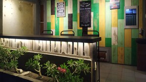 A restaurant interior with a counter, chairs, and a menu board. - Write Hostel (Penida Island)