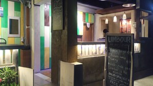 A restaurant interior with a chalkboard menu, colorful walls, and pendant lighting. - Write Hostel (Penida Island)