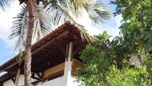 A two-story building with a tiled roof and a balcony. - Macambira Café Pousada (Delmiro Gouveia)