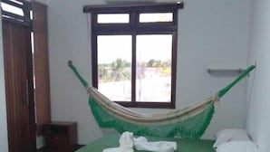 A room with a bed, a window, a hammock, and a small table. - Macambira Café Pousada (Delmiro Gouveia)
