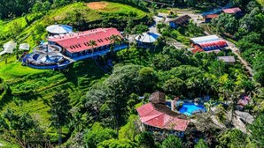 Een resort met meerdere gebouwen, een zwembad en weelderige groene omgeving.