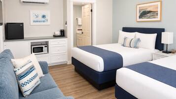 Une chambre d’hôtel avec deux lits, un canapé, une kitchenette et une salle de bain.