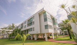 A modern multi-story hotel with a flat roof, large windows, and a covered outdoor area with palm trees. - Premier Residence Hplus Long Stay (Brasília)
