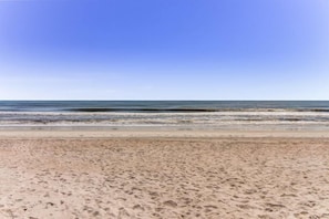 A beach with a sandy shore and calm ocean waves. - 212-sailmaker (Fernandina Beach)