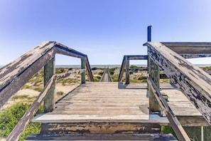 A wooden boardwalk leading to a beach with a clear sky. - 212-sailmaker (Fernandina Beach)