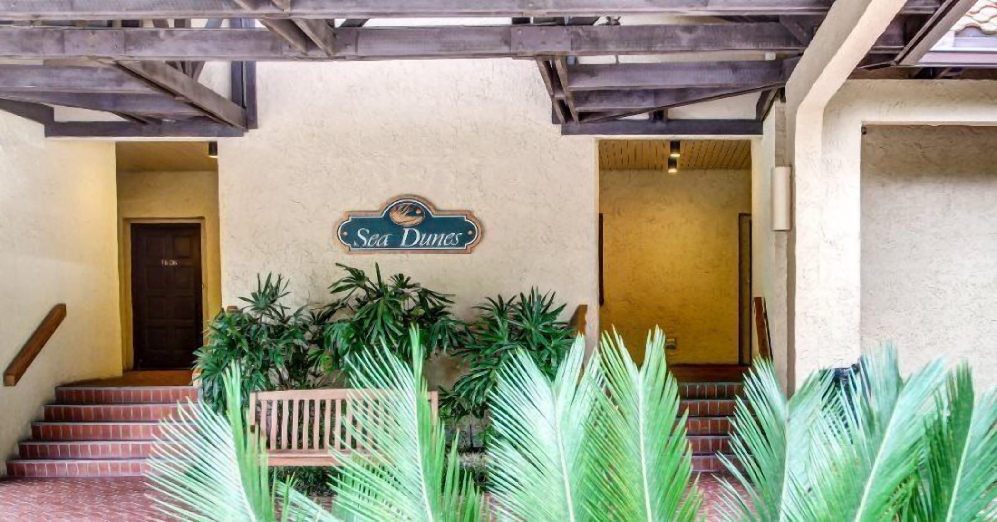 A hotel entrance with a sign reading "Sea Dunes."