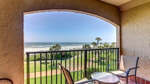 A balcony with a view of the ocean, a chair, and a table. - 1637-38-sea-dunes (Fernandina Beach)
