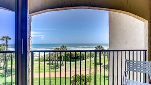 A balcony with a view of the ocean, a white chair, and a pathway leading to the beach. - 1637-38-sea-dunes (Fernandina Beach)