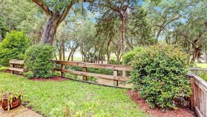 A park with a wooden fence, various trees, and well-maintained grass. - 2135-beachwood (Fernandina Beach)