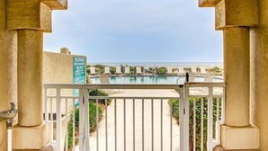 A pool area with a view of the sea, a sign indicating no lifeguard on duty, and a white railing. - 69-ocean Place (Fernandina Beach)