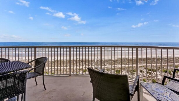 A balcony with a view of the beach, furnished with wicker chairs and a table. - 69-ocean Place (Fernandina Beach)