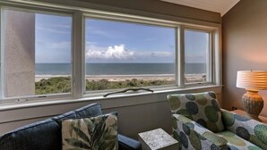 A room with a view of the beach through three windows. There is a lamp on a side table. - 1114-beach-walker (Fernandina Beach)
