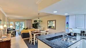 Habitació d'hotel amb zona de menjador, petita cuina i finestra gran.
