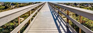 A wooden boardwalk leading to a beach with a clear view of the ocean. - 13-ocean-place (Fernandina Beach)