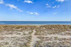 A beach with a clear sky and a sandy path leading to the water. - 608-sailmaker (Fernandina Beach)