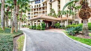 A hotel with a central courtyard, palm trees, and a covered entrance.