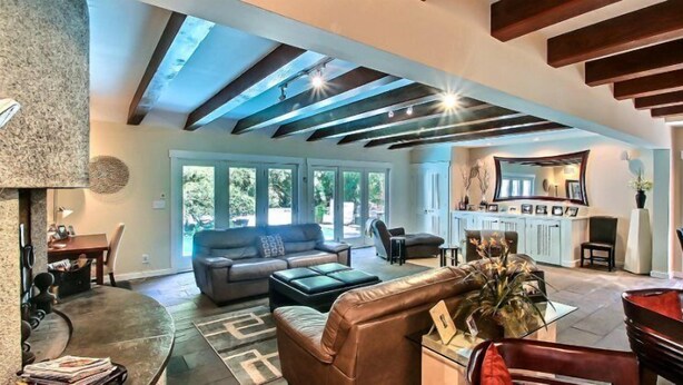A spacious living room with a high ceiling, large windows, and a fireplace. - 17-beach-walker-road (Fernandina Beach)