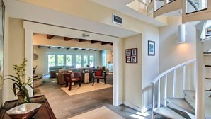 A spacious living area with a staircase leading to an upper level. - 17-beach-walker-road (Fernandina Beach)