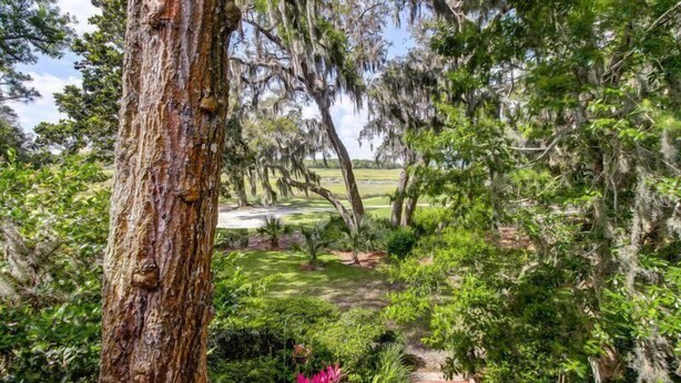A lush garden with a variety of plants and a brick pathway. - 3062-club-villas (Fernandina Beach)