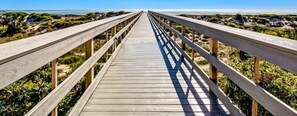 A wooden boardwalk leading to a beach with a clear view of the ocean. - 3062-club-villas (Fernandina Beach)