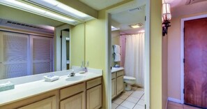 A bathroom with a large mirror, a sink, and a toilet.